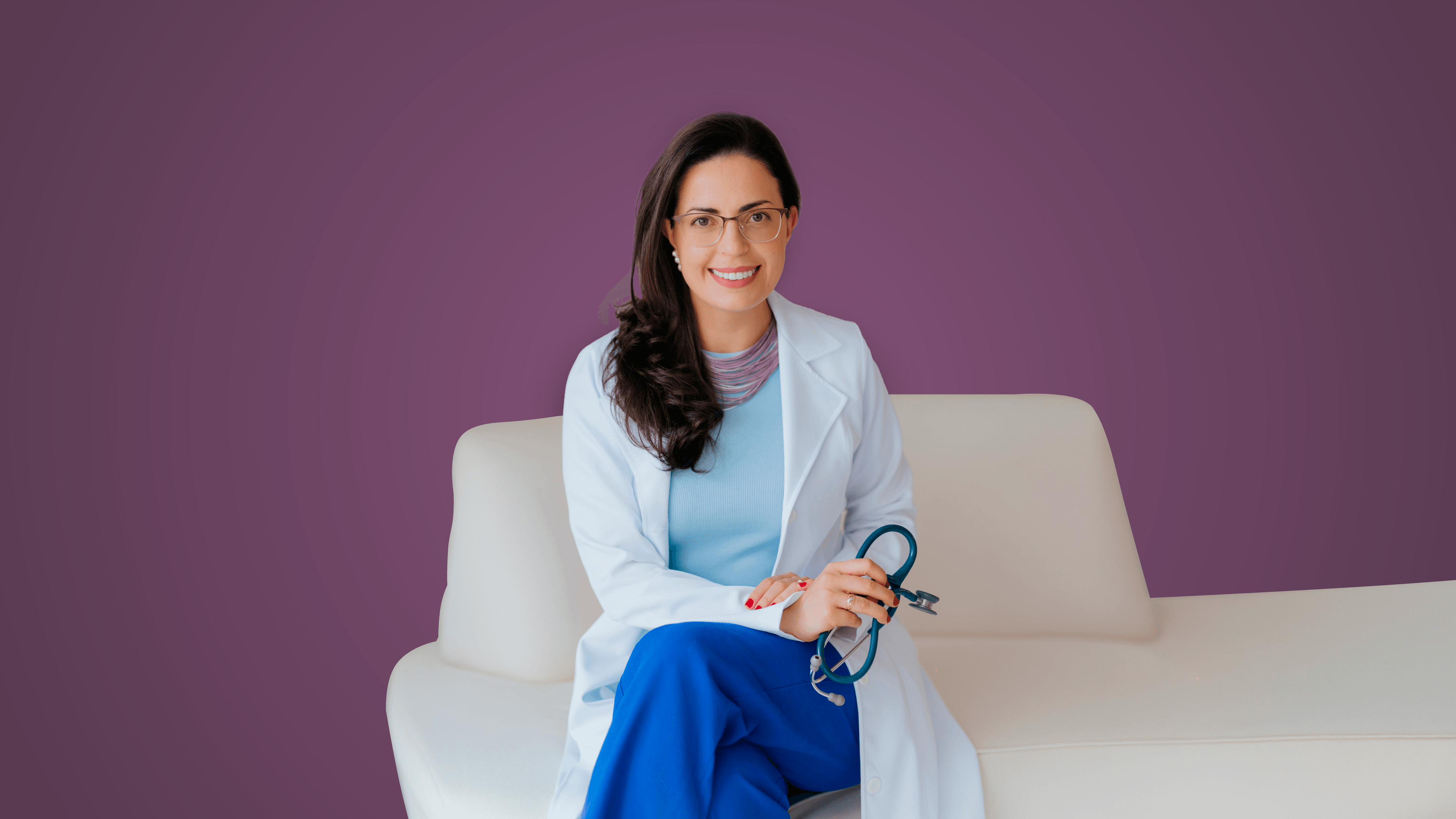 Dra. Gerusa Vilas-Bôas, cardiologista pediátrica, sentada com um estetoscópio nas mãos.